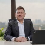Confident middle-aged businessman in an elegant office with city view.